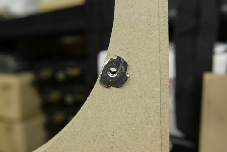 A close up of a T-Nut. One prong was ground off. These are solid. I used a C-clamp to squeeze these in place after drill pressing appropriate sized pilot holes.